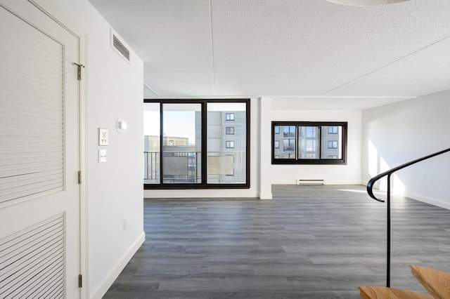 corridor featuring dark hardwood / wood-style floors, a textured ceiling, and baseboard heating