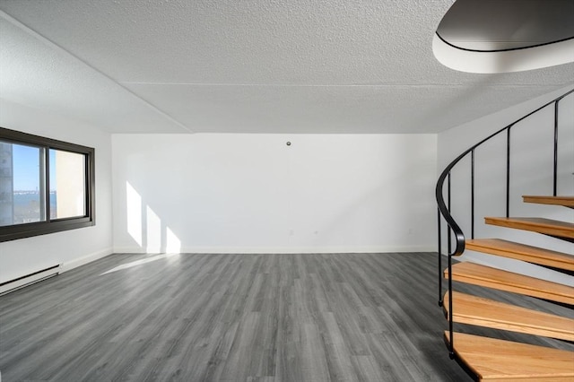 interior space with hardwood / wood-style flooring, a baseboard radiator, and a textured ceiling