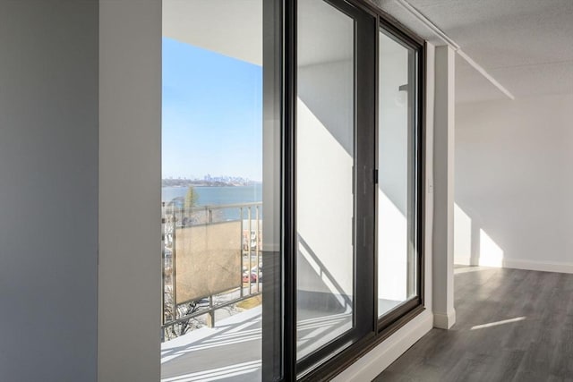 doorway to outside with a water view and dark hardwood / wood-style floors