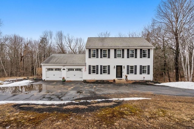 view of front of property featuring driveway, an attached garage, and roof with shingles