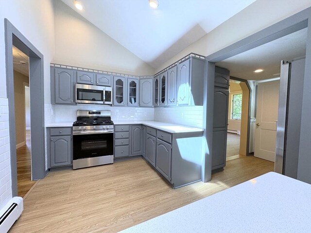 6 Oak St, Foxboro, MA 02035 - kitchen with appliances with stainless steel finishes, baseboard heating, gray cabinetry, glass insert cabinets, and lofted ceiling