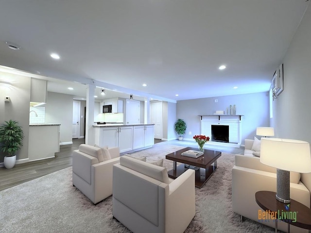 6 Oak St, Foxboro, MA 02035 - living area featuring light wood-style flooring, recessed lighting, baseboards, a fireplace, and decorative columns