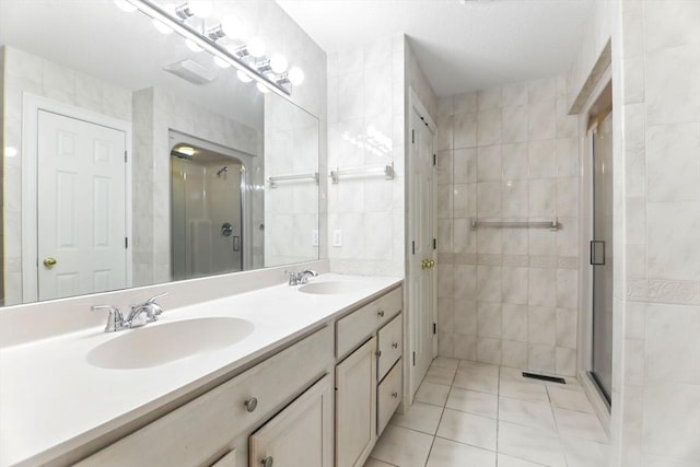 102 Pinehurst Dr Unit 102, East Longmeadow, MA 01028 - bathroom featuring tile patterned floors, tile walls, a shower stall, and a sink