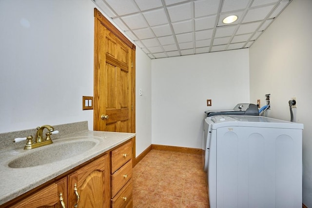 clothes washing area featuring laundry area, light tile patterned flooring, baseboards, washer / clothes dryer, and a sink