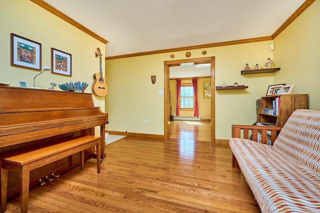 living area with baseboards, ornamental molding, and light wood-style flooring