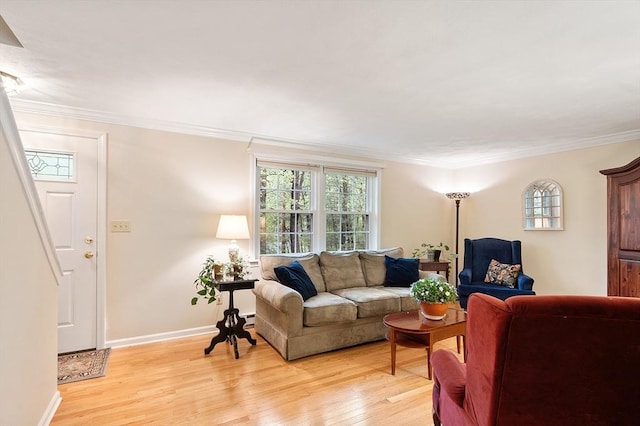 living area featuring light wood finished floors, crown molding, a wealth of natural light, and baseboards