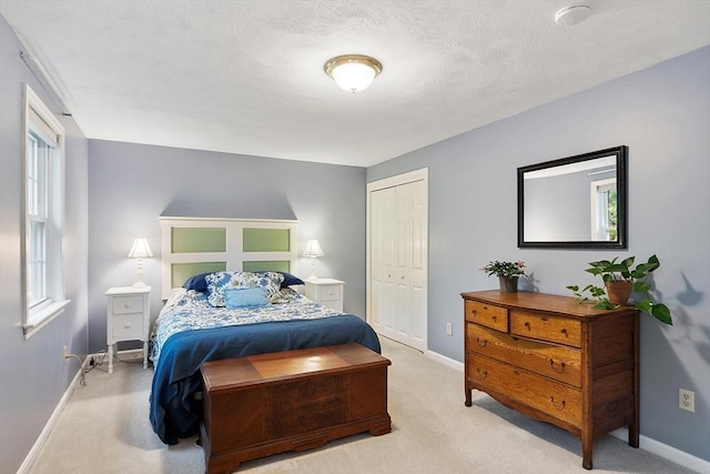 carpeted bedroom with baseboards, a closet, and a textured ceiling