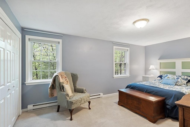 carpeted bedroom featuring a baseboard heating unit, baseboards, a closet, and multiple windows