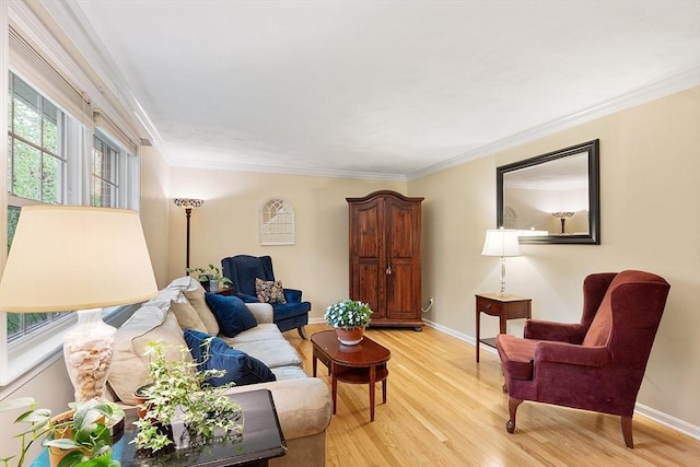 living room featuring baseboards, ornamental molding, and light wood finished floors