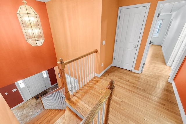 staircase with a chandelier and wood-type flooring