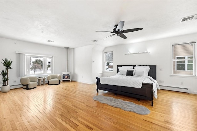 bedroom featuring baseboard heating, ceiling fan, and light wood-type flooring