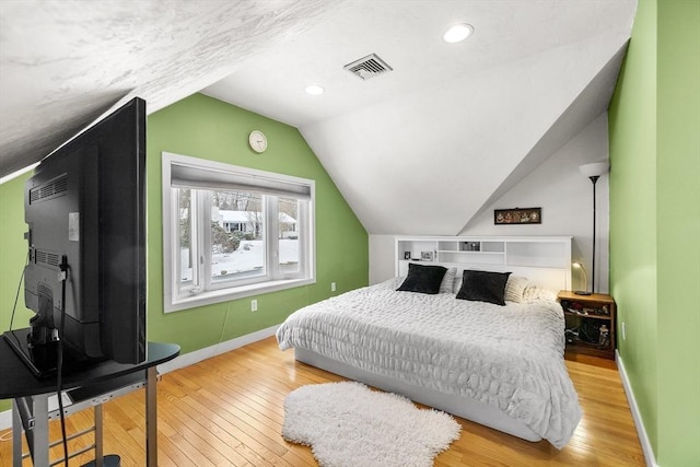 bedroom with wood-type flooring and vaulted ceiling