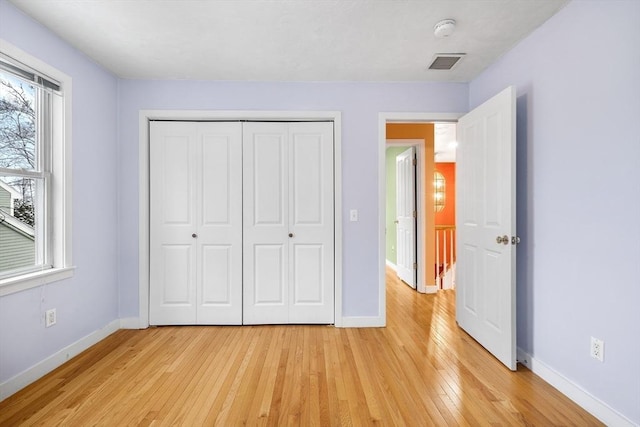 unfurnished bedroom with a closet and light hardwood / wood-style floors