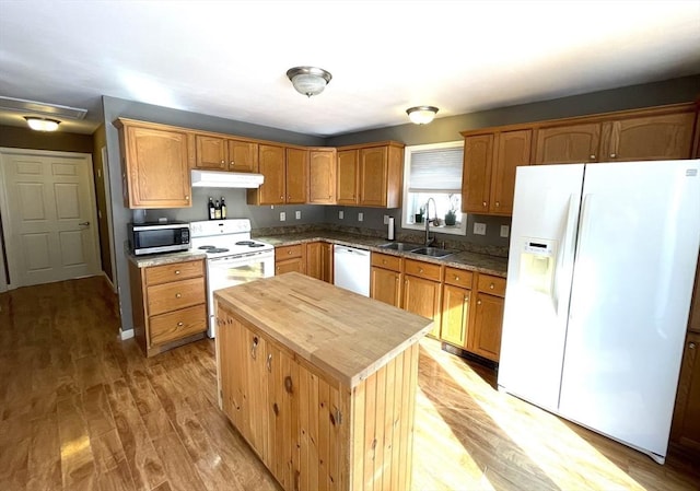 kitchen featuring sink, wooden counters, light hardwood / wood-style flooring, a kitchen island, and white appliances