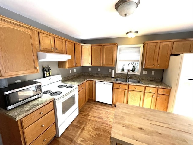 kitchen with white appliances, butcher block counters, sink, and hardwood / wood-style floors