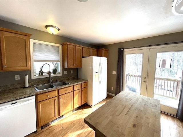 kitchen featuring french doors, butcher block counters, sink, light hardwood / wood-style flooring, and white appliances