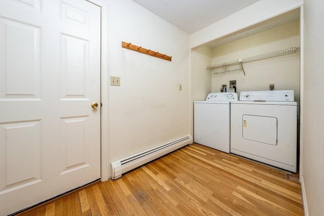 clothes washing area featuring laundry area, a baseboard radiator, separate washer and dryer, and light wood finished floors