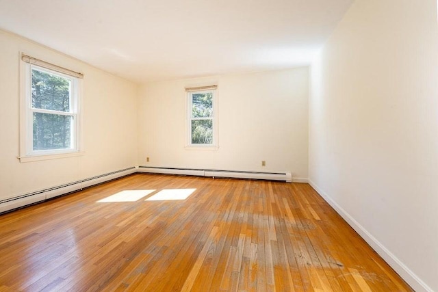 unfurnished room featuring light wood-type flooring, a baseboard radiator, and baseboards