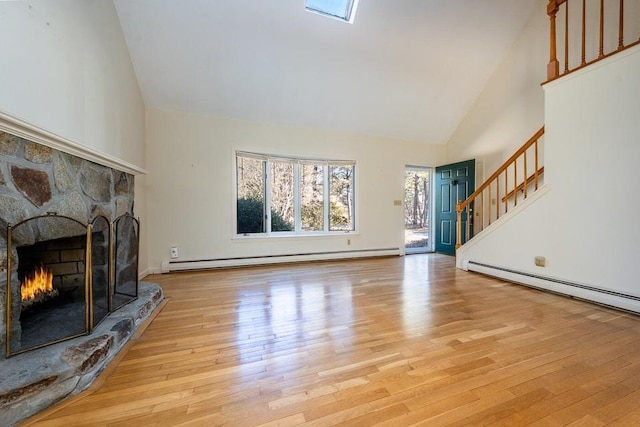 living room with high vaulted ceiling, a baseboard radiator, a fireplace, stairs, and light wood-type flooring