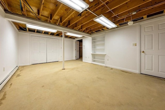 unfinished basement featuring baseboards and a baseboard heating unit