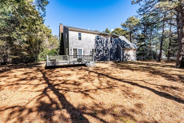 rear view of house with a chimney and a wooden deck