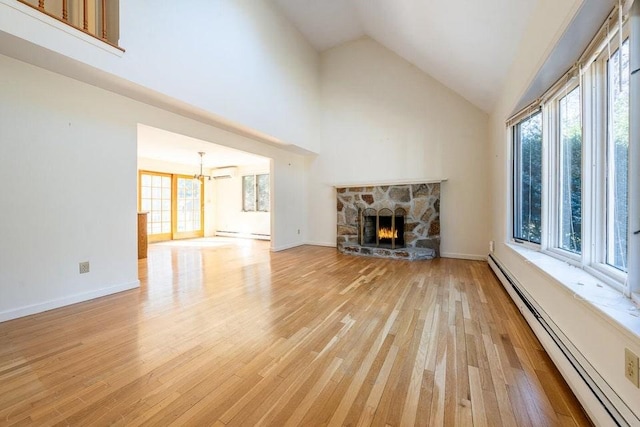 unfurnished living room featuring light wood-style floors, a fireplace, baseboard heating, and a wall mounted AC