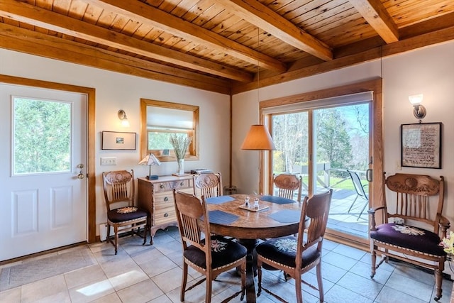 dining area with beamed ceiling, a healthy amount of sunlight, and light tile patterned flooring