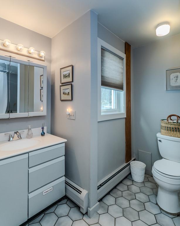 bathroom featuring vanity, tile patterned floors, toilet, baseboards, and baseboard heating