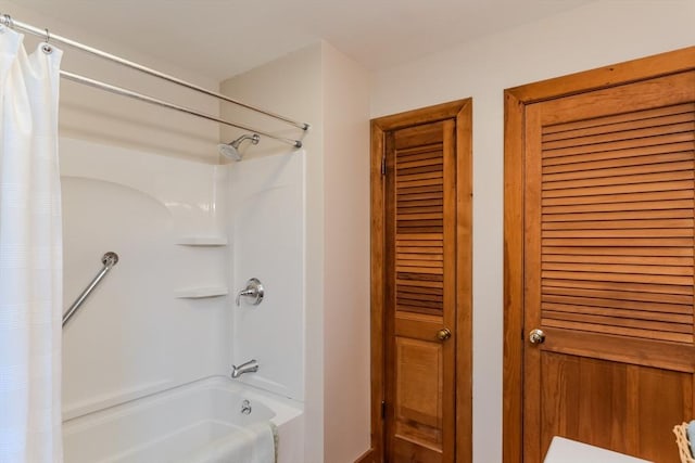 full bathroom with shower / bath combo with shower curtain and a closet