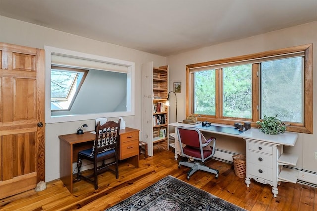 office featuring a baseboard radiator, wood finished floors, and a skylight