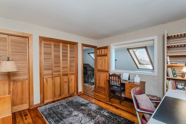 office space with wood finished floors and a skylight