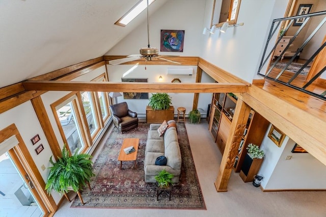 interior space with a healthy amount of sunlight, ceiling fan, an AC wall unit, and vaulted ceiling with skylight