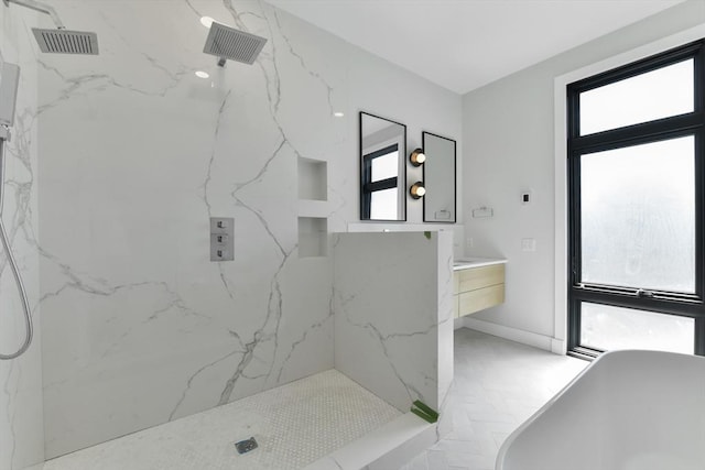full bathroom featuring visible vents, baseboards, vanity, a marble finish shower, and a soaking tub