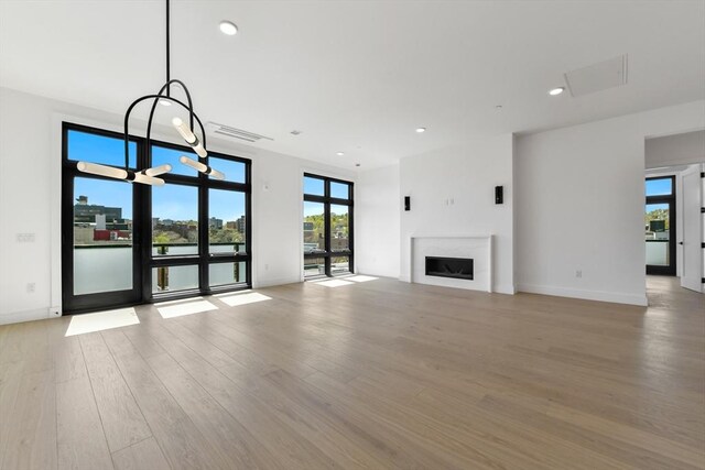 unfurnished living room featuring visible vents, a fireplace, baseboards, light wood-style floors, and recessed lighting