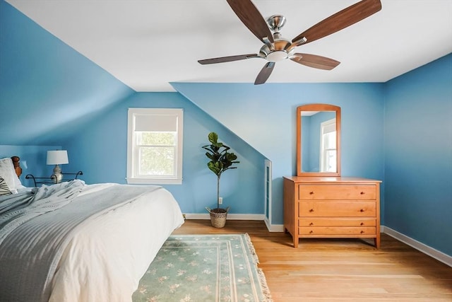 bedroom with lofted ceiling, baseboards, ceiling fan, and light wood finished floors