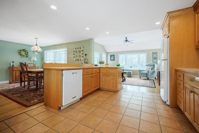 kitchen featuring decorative light fixtures, light tile patterned floors, light countertops, open floor plan, and white appliances