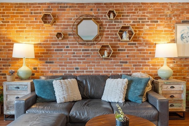 living room with brick wall and hardwood / wood-style floors