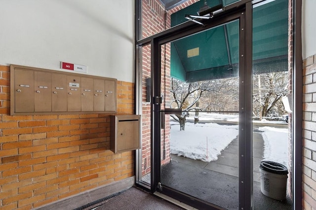 entryway with brick wall and a mail area