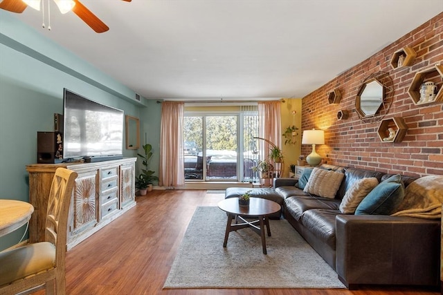 living room featuring hardwood / wood-style flooring and brick wall