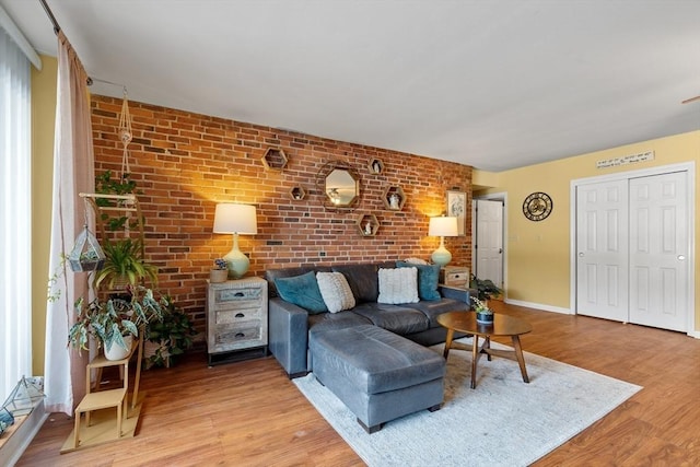 living room with wood-type flooring and brick wall