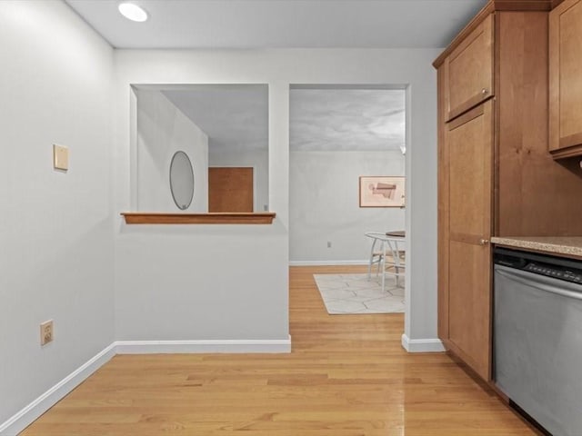 kitchen featuring stainless steel dishwasher, light wood-style flooring, baseboards, and brown cabinetry