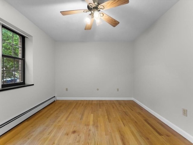 unfurnished room with baseboard heating, light wood-style flooring, baseboards, and ceiling fan