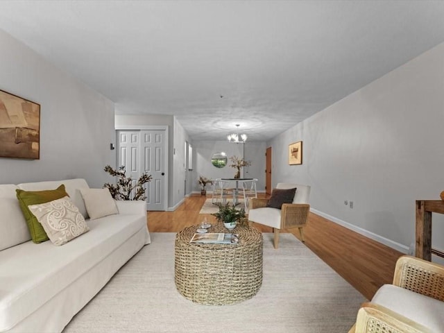 living area with wood finished floors, baseboards, and a chandelier