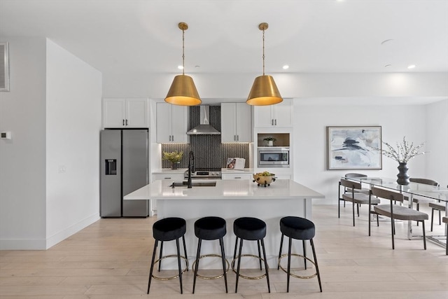 7 Wordsworth Unit Ph6, Boston, MA 02128 - kitchen with wall chimney exhaust hood, stainless steel appliances, light countertops, light wood-type flooring, and recessed lighting