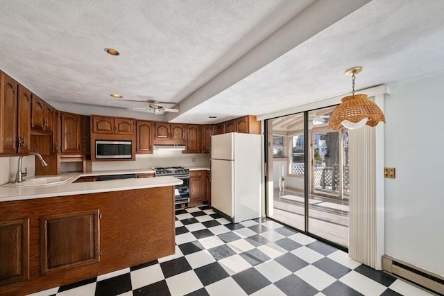 kitchen featuring sink, hanging light fixtures, appliances with stainless steel finishes, kitchen peninsula, and a baseboard heating unit