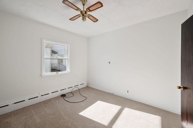 spare room with light carpet, a baseboard radiator, and ceiling fan