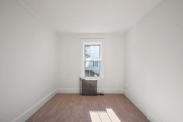 empty room featuring radiator, crown molding, and light colored carpet