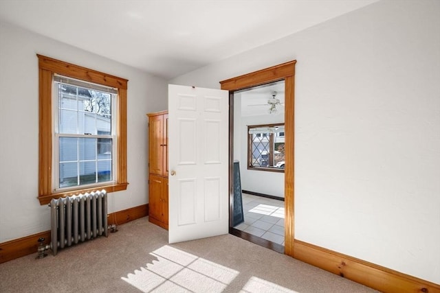 carpeted empty room featuring radiator heating unit