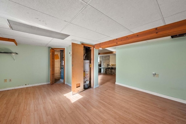 interior space with a paneled ceiling, light hardwood / wood-style floors, and gas water heater