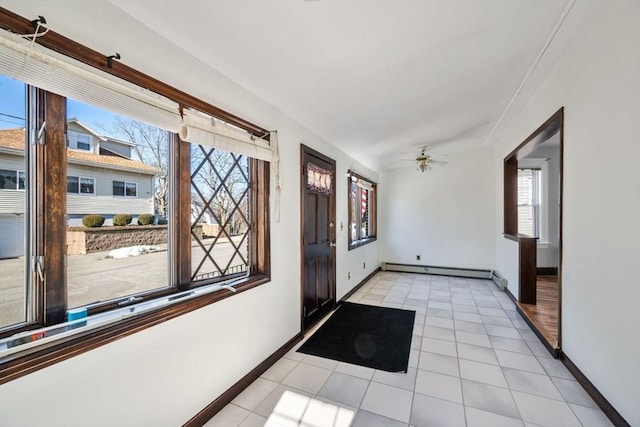 tiled foyer entrance featuring baseboard heating and ceiling fan